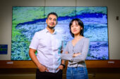 Photo of the researchers standing in front of a projected image of a permafrost slump.