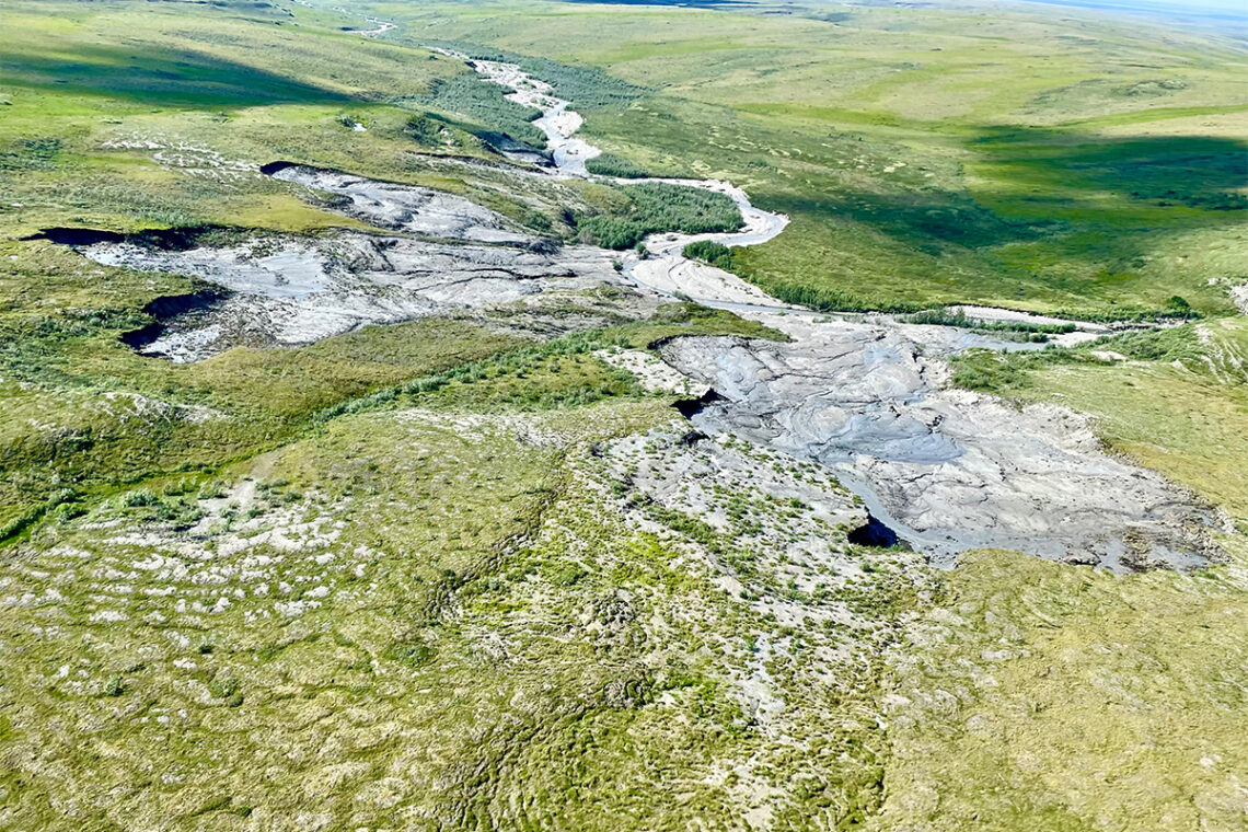 Photo of three slumps that converge near the center of the photo in what appears to be a hillside. Edges in dark shadow mark some of the deepest areas of the slumps. 
