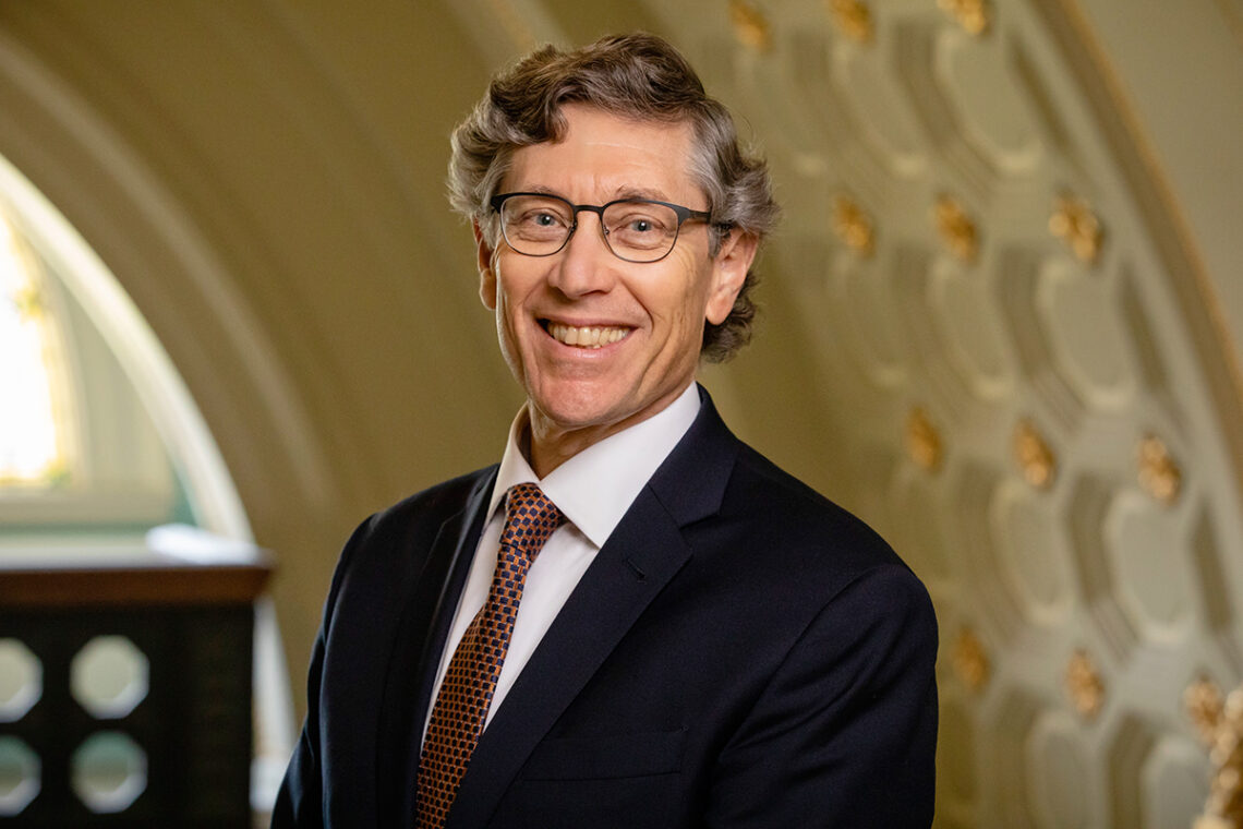 Photo of Robinson standing under an arch.