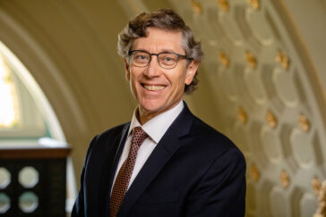 Photo of Robinson standing under an arch.