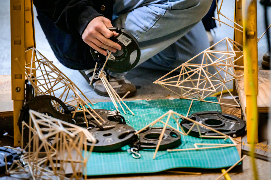 Photo of the remnants of a truss made from bamboo sticks and the weights that were attached to it.