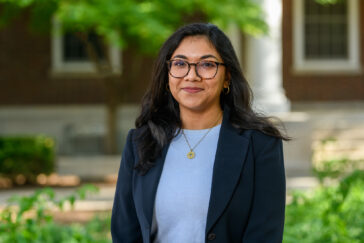 Doctoral student Shaimaa Khanam standing outdoors with the column of a campus building in the background.