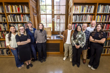 Photo of a group of students in the Ricker Library of Architecture and Art, in front of a windowsill with an exhibit of architectural models.