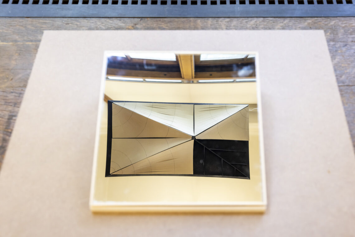 Photo of the model of a roof canopy, reflected in a mirror, in the Ricker Library of Architecture and art.