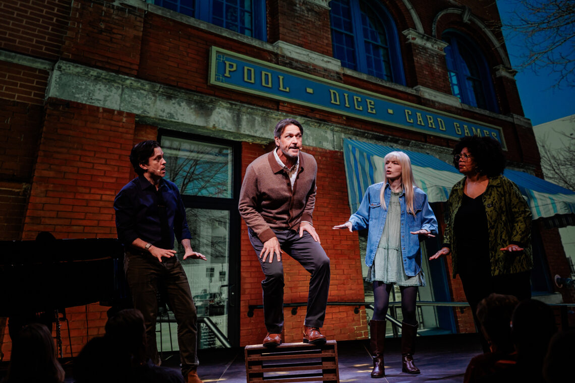 Photo of Ben Jones, Nathan Gunn, Catheryn Kuhar and Adrienne Danrich performing on stage in front of a backdrop of a gaming house.
