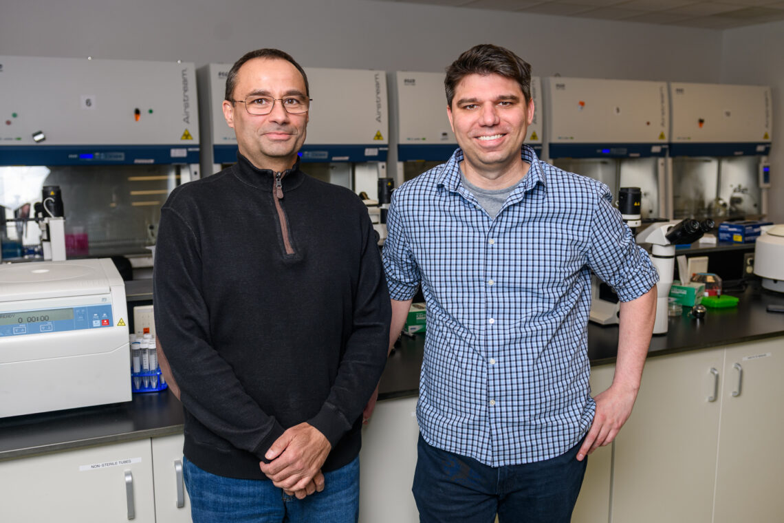 Two men stand in a lab