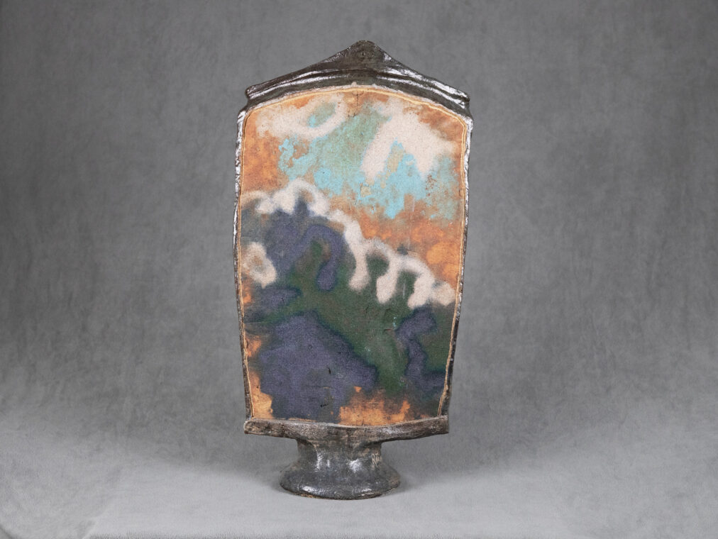 Photo of a multicolored ceramic panel with orange, blue, green and cream colors.