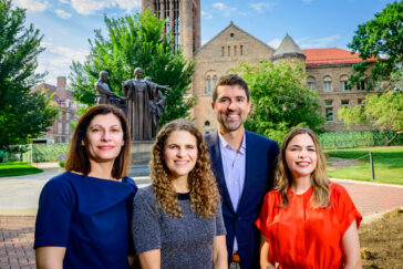 College of Education Dean Chrystalla Mouza, Director of Public Engagement Emily Stone, and educational psychology professors Chris Napolitano and Kaylin Ratner standing in front of the Alma Mater statue on the Illinois campus.