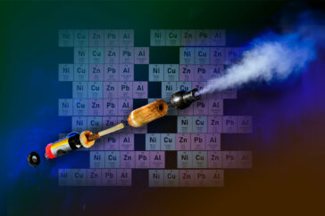 The image shows a photo illustration of an e-cig, broken down to its components, in front of an excerpt of the periodic table of elements focused on lead, zinc and copper.