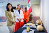 Photo of Verónika Bustamante Gómez, Elizabeth Sutton and Venetria Patton standing before a table with Peruvian objects at the museum.