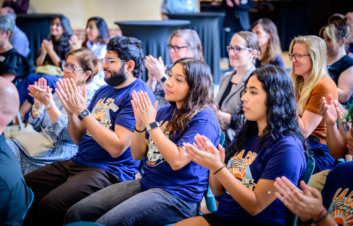 Photo of several seated students applauding.