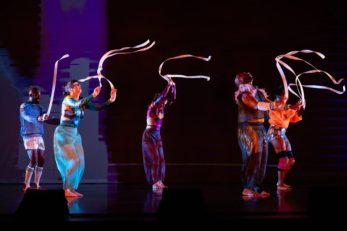 Photo of dancers moving ribbons in the air.