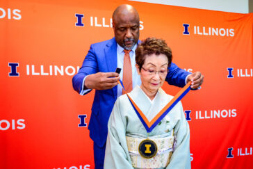 Photo of Chancellor Charles L. Isbell Jr. placing the Chancellor's Medallion around Kimiko Gunji's neck.